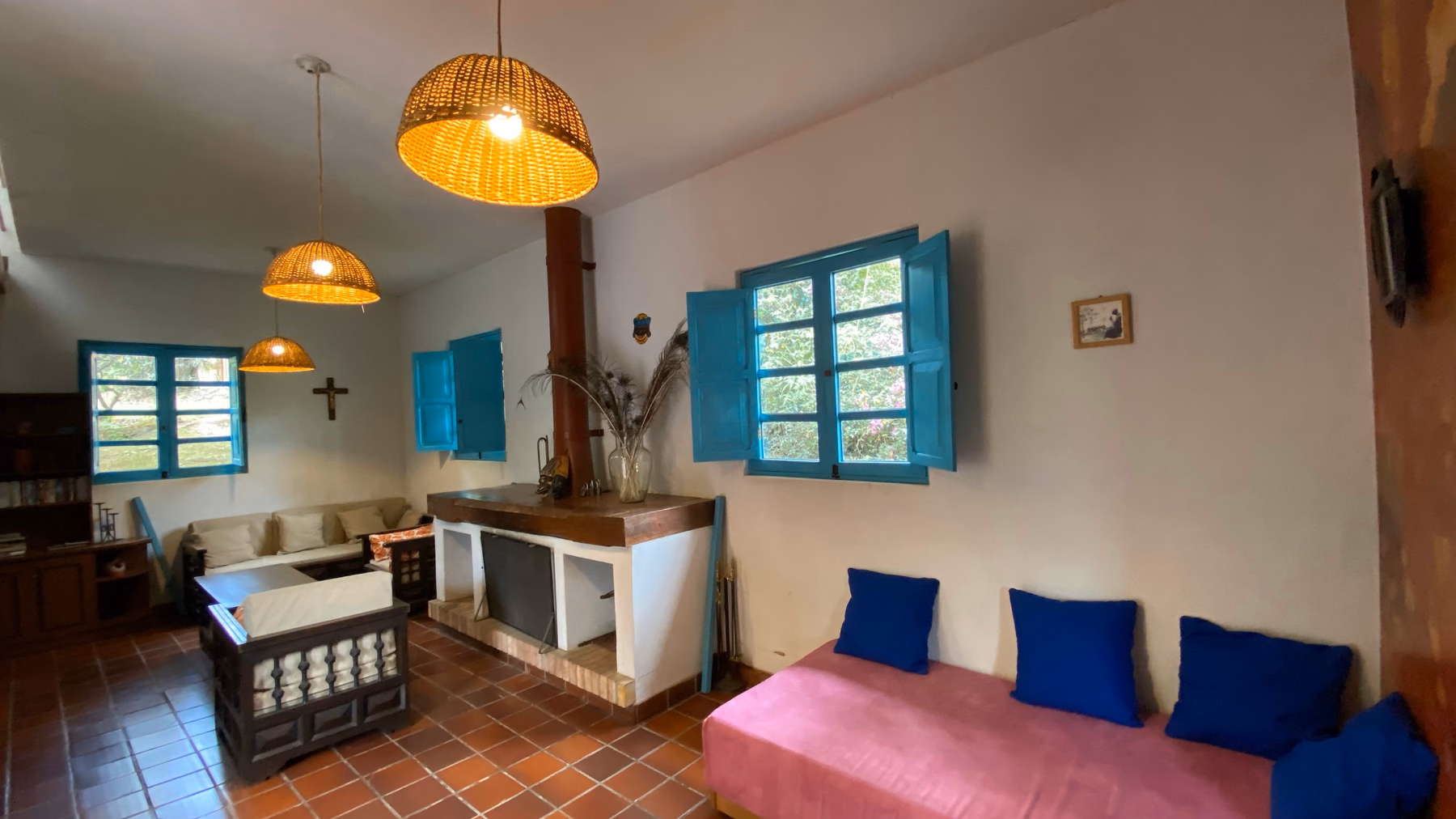Sala principal de Sans-Souci con chimenea, lámparas de mimbre y ventanas azules